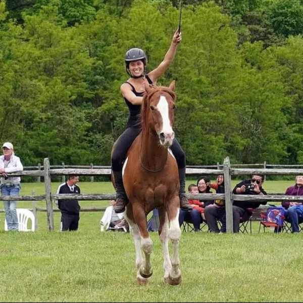 A woman riding on the back of a brown horse.